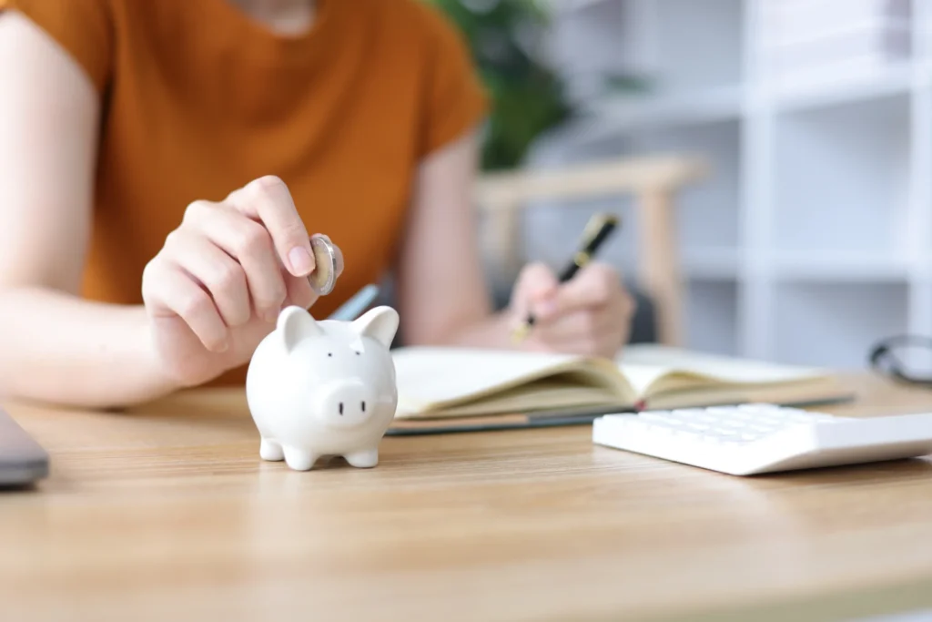 豚の貯金箱にお金をいれる