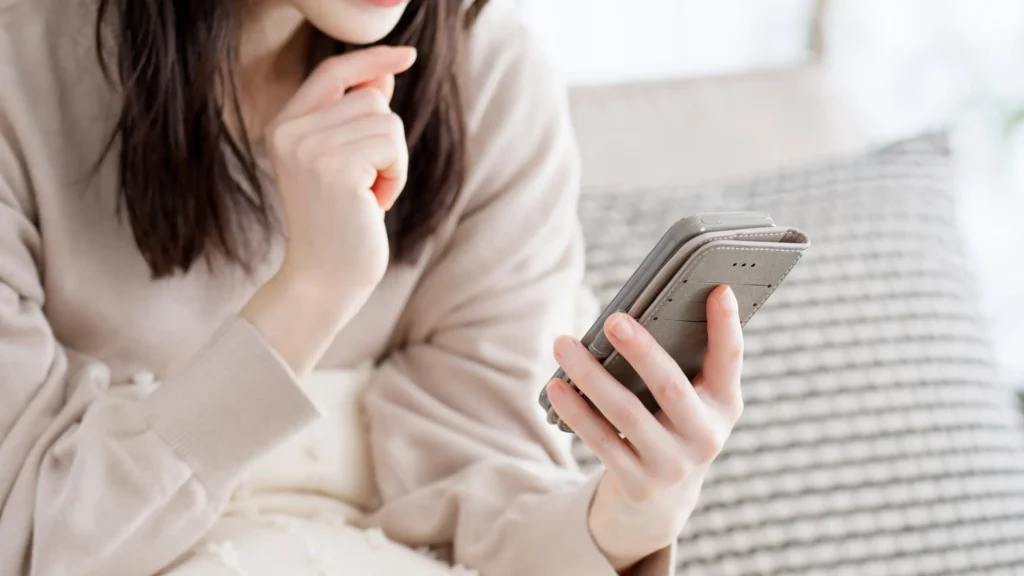 携帯でアプリを見る女性