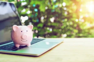 パソコンの上に豚の貯金箱がのっている