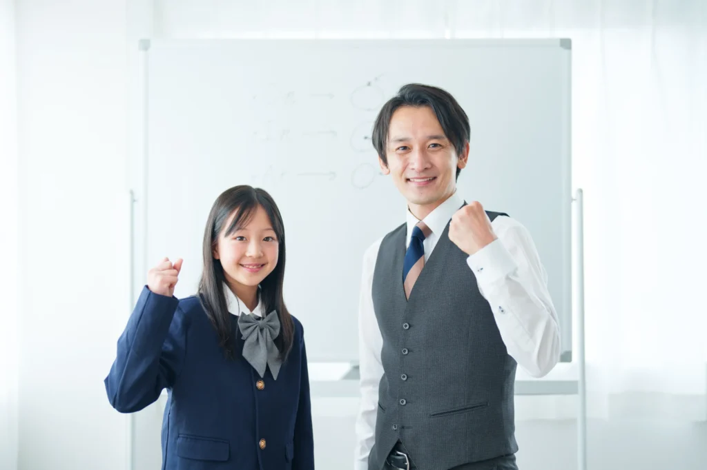 ガッツポーズをする先生と生徒