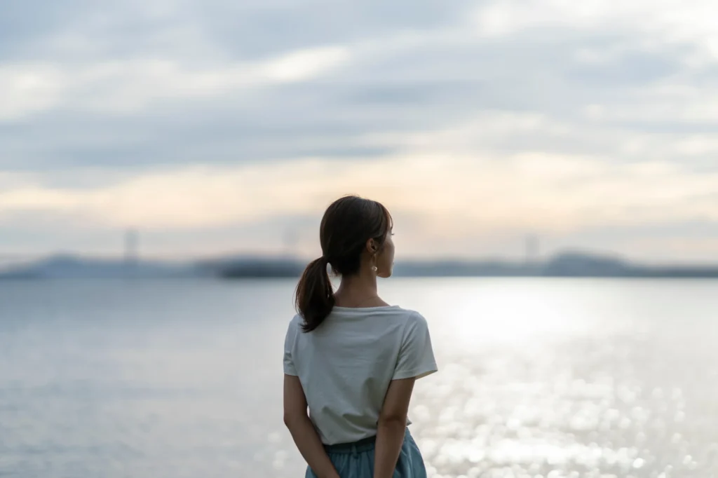 夕暮れの海にいる女性