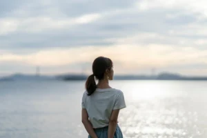 夕暮れの海にいる女性