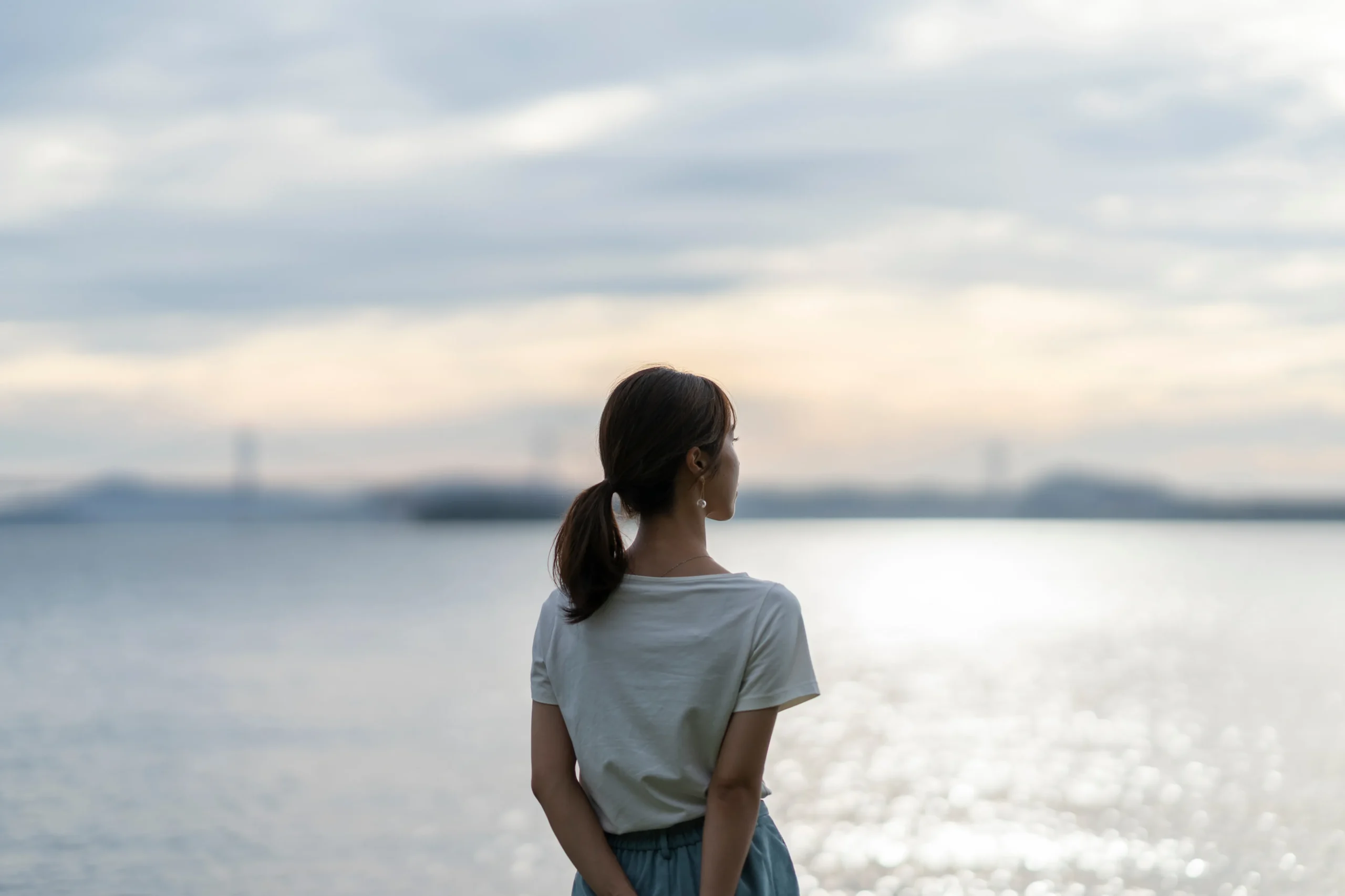 夕暮れの海にいる女性
