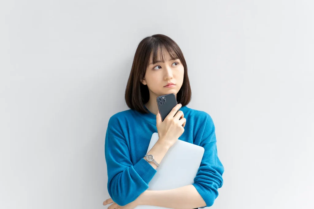 スマホを持って考える女性