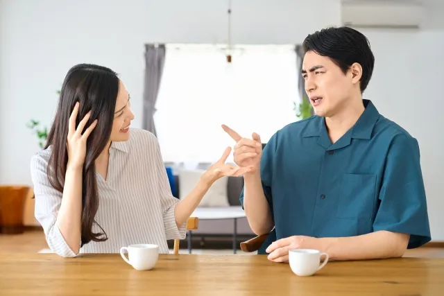リビングで言い争いをする若い夫婦