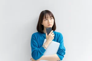 スマホを持って考える女性