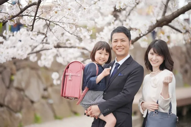 桜の花の前で笑う家族